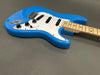 Electric guitar with blue body, white pickguard, three single-coil pickups, maple neck, and black control knobs on gray background