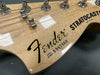Close-up of Fender Stratocaster guitar headstock with serial number S967809 and tuning pegs, made in USA, natural wood finish