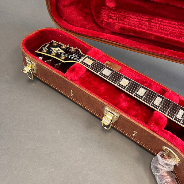 Greco electric guitar neck and headstock with pearl inlays inside brown hard case with red plush interior lining and gold latches