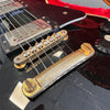 Close-up of worn vintage electric guitar bridge and pickup with black glossy finish and control knobs
