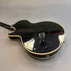 Black electric guitar back with cream binding and control cavity cover on grey background