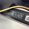 Close-up of a guitar body edge resting on a digital scale displaying a weight of 10 pounds 6.7 ounces