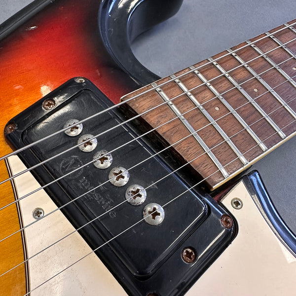 Close-up of vintage electric guitar with Mosrite single coil pickup, sunburst finish, and rosewood fretboard with metal frets and dot inlays
