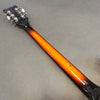 Back of guitar neck with sunburst finish and chrome tuning pegs on gray background