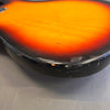 Close-up of sunburst electric guitar body edge showing wear and scratches on black finish