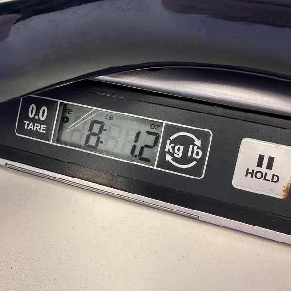 Digital scale display showing 8 pounds 1.2 ounces weight with tare and hold buttons, close-up view.