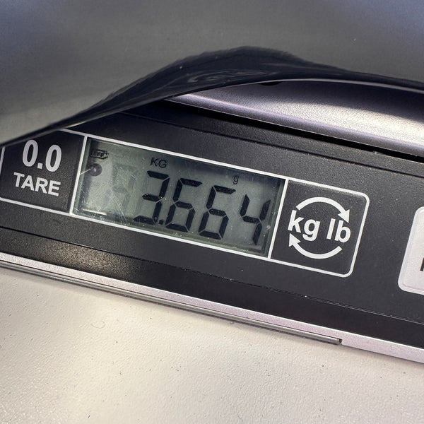 Digital scale display showing the weight of a guitar as 3.664 kilograms, with kg and lb conversion option and tare function visible.