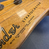 Close-up of Fender Stratocaster guitar headstock with synchronized tremolo text and tuning pegs