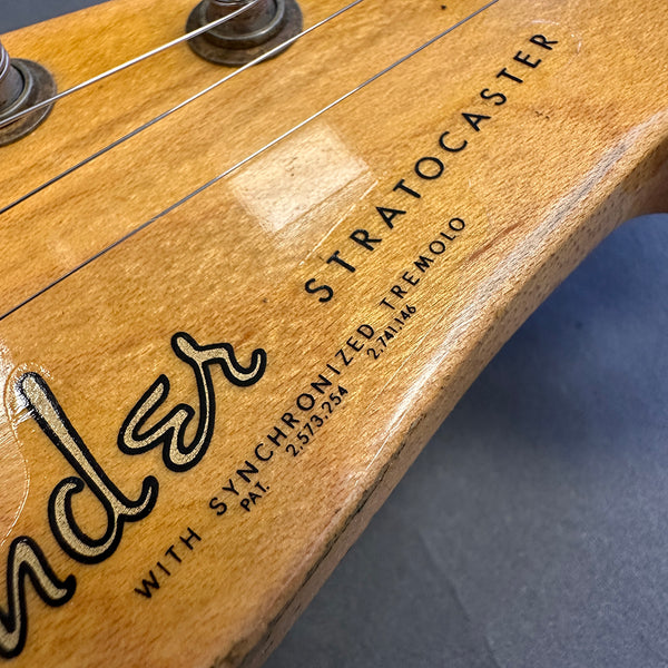Close-up of Fender Stratocaster guitar headstock with synchronized tremolo text and tuning pegs