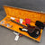 Fender electric bass guitar in glossy black finish with tortoiseshell pickguard in open hard shell case with orange plush interior, Fender manuals and accessories