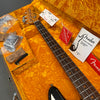 Fender bass guitar neck and headstock with accessories in vintage orange plush-lined hard case including care manual, strings, and tags