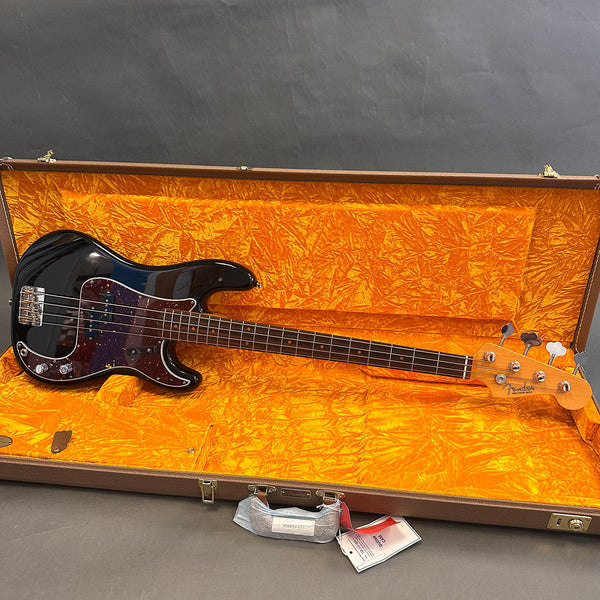 Fender Precision Bass guitar in black with tortoiseshell pickguard inside open vintage orange plush-lined hard case