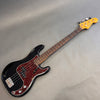 Fender Precision Bass guitar in black with tortoiseshell pickguard and maple neck on gray background