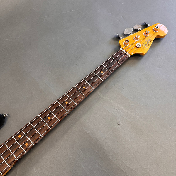 Fender Precision Bass guitar neck with rosewood fingerboard and vintage-style tuning pegs on gray background