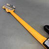 Maple neck of electric bass guitar with chrome tuning pegs on gray background