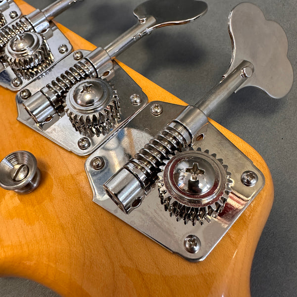 Close-up of chrome tuning pegs and gears on natural wood electric guitar headstock at Coffee House Guitars.