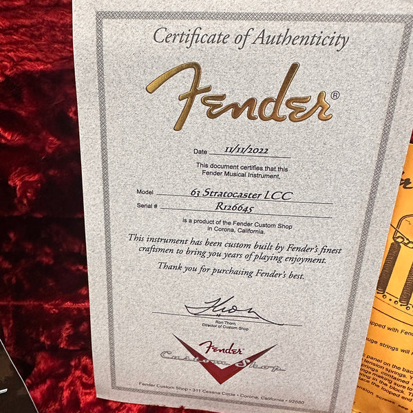 Fender Certificate of Authenticity for 63 Stratocaster LCC guitar with serial number R126645 dated 11/11/2022, signed by Ron Thorn, Director of Custom Shop, on textured paper with Fender Custom Shop logo and red velvet background