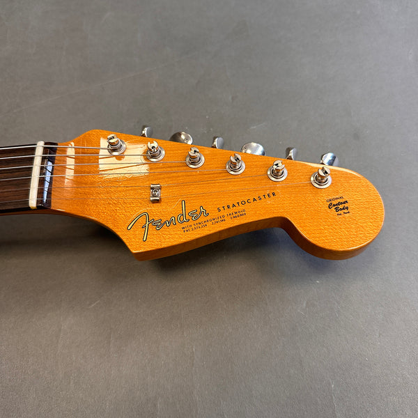 Fender Stratocaster guitar headstock with original contour body logo and chrome tuning pegs on gray background