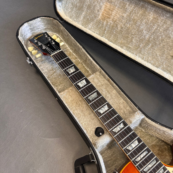 Greco electric guitar neck with mother of pearl block inlays and vintage tuners inside a plush lined hard case on a gray surface