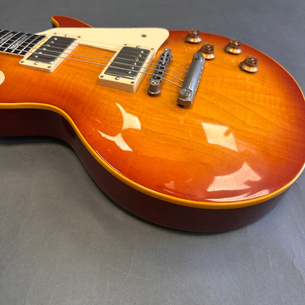 Close-up of vintage sunburst electric guitar body with humbucker pickups and chrome bridge on gray background