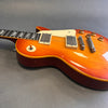 Cherry sunburst electric guitar with dual humbucker pickups and cream pickguard on gray background