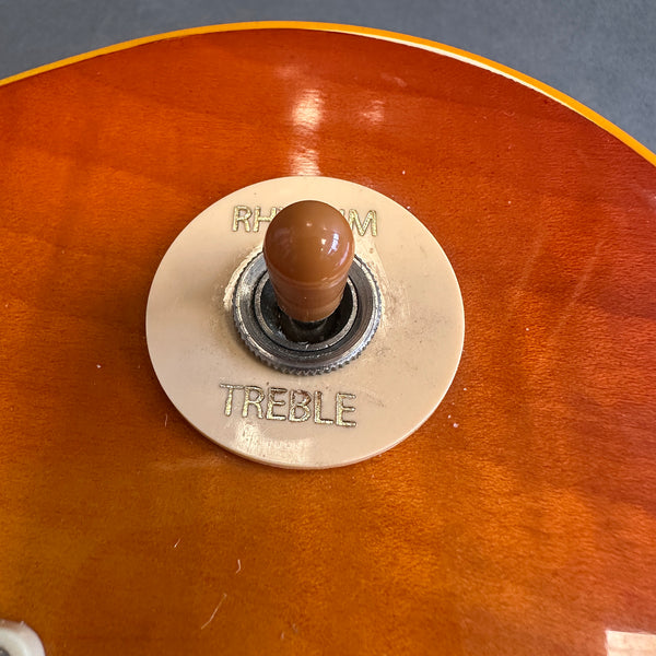 Close-up of vintage guitar pickup selector switch on sunburst electric guitar body with "RHYTHM" and "TREBLE" labeled selector ring