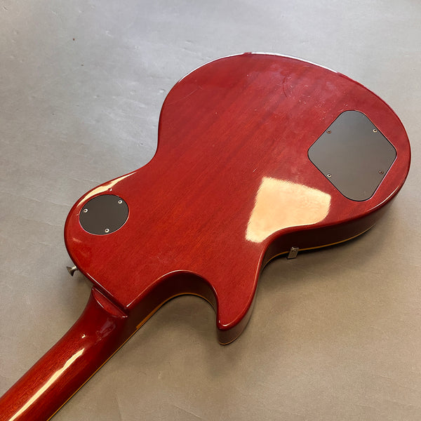 Cherry red electric guitar rear body view showing glossy finish and control cavity covers
