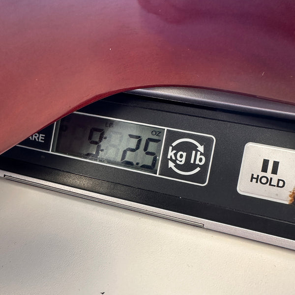 Close-up of digital scale showing weight 9 pounds 2.5 ounces with part of red guitar body on top, Coffee House Guitars product weight display