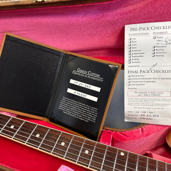 Gibson Custom Certificate of Authenticity and Pre-Pack Checklist inside guitar case with partial guitar neck visible on red velvet lining