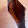 Close-up of Gibson Custom guitar warranty label inside hollow body guitar with natural wood finish and purple binding