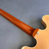 Close-up of guitar neck and body joint showing polished wood grain and smooth finish on electric guitar at Coffee House Guitars