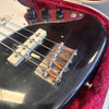 Close-up of black electric bass guitar bridge, strings, and control knobs in red velvet case for sale at Coffee House Guitars