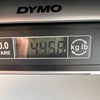 Digital DYMO scale display showing guitar weight as 4.456 pounds for Coffee House Guitars product listing.