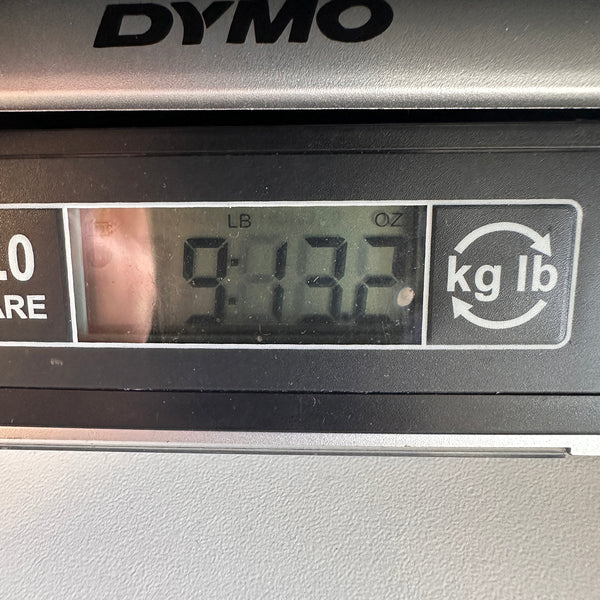 Close-up of a digital scale display showing the weight of 9 pounds 13.2 ounces for a guitar at Coffee House Guitars.