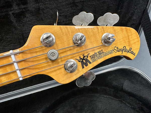 Ernie Ball Music Man StingRay Bass guitar headstock with tuning pegs and strings in black plush-lined guitar case