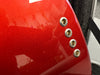 Close-up of red electric guitar body showing four string ferrules and glossy metallic finish