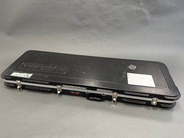 Black hard shell guitar case with Music Man logo and metal latches, designed for electric guitar storage and transport.