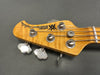 Close-up of maple guitar headstock with PRNT-BALL MUSICMAN StingRay Bass logo and four tuning pegs on gray background
