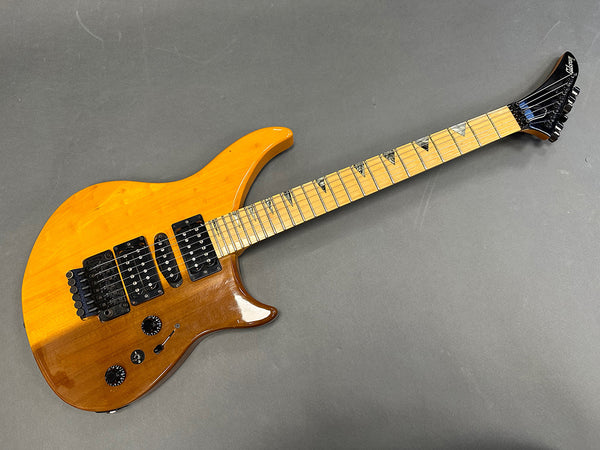 Vintage Gibson electric guitar with natural wood finish, maple fretboard with shark tooth inlays, dual humbucker pickups, black hardware, and Floyd Rose tremolo system