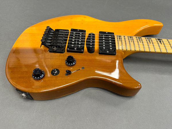 Honey sunburst electric guitar with black humbucker and single coil pickups, maple fretboard, and Floyd Rose tremolo system on gray background