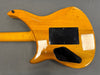 Back view of a yellow electric guitar showing the wood grain and black plastic access panels on a gray background
