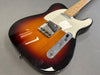Sunburst finish electric guitar with chrome hardware and maple neck on gray background