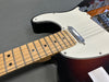 Close-up of electric guitar neck and body showing maple fretboard, white pickguard, and single-coil pickup on sunburst finish guitar