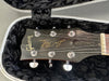 Close-up of Gibson Les Paul Model Deluxe guitar headstock with tuning pegs in black padded guitar case interior