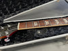 Close-up of Gibson Les Paul Deluxe guitar neck with pearl block inlays in black plush hard case at Coffee House Guitars