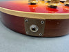 Close-up view of vintage electric guitar input jack plate and control knobs on sunburst finish guitar body