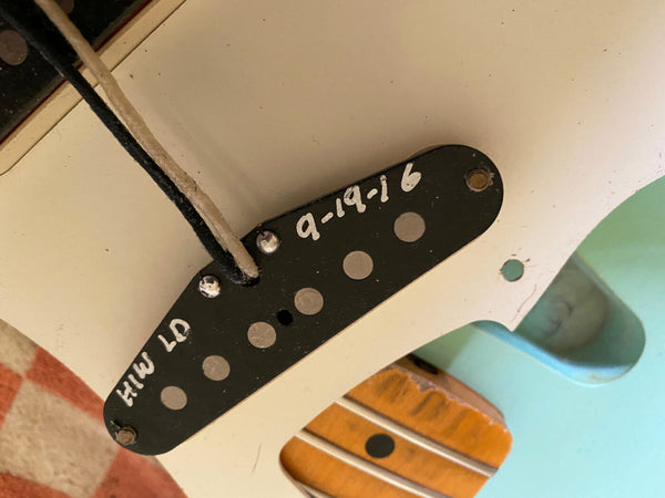 Close-up of vintage guitar single-coil pickup with hand-painted date 9-19-16 and markings inside guitar body showing wiring and part of maple neck fingerboard.