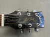 Close-up of Gibson Les Paul Deluxe electric guitar headstock showing tuning pegs, logo, and strings on gray background