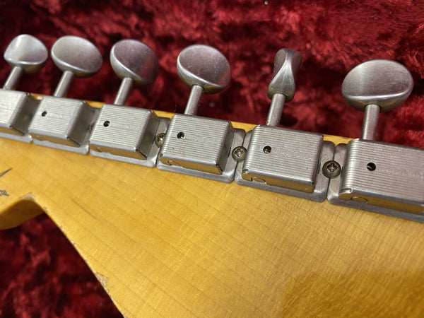 Close-up of vintage vintage metal guitar tuning pegs on maple headstock with a red plush background