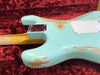 Close-up of vintage relic worn light blue electric guitar body with neck joint and chrome neck plate on red plush guitar case interior